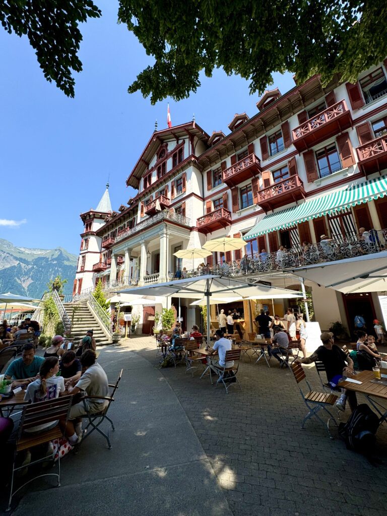 Terrace of Grand Hotel Giessbach with guests dining outdoors overlooking Lake Brienz