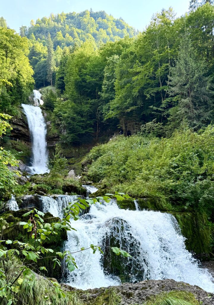 Scenic view of Giessbach Waterfalls framed by forest trees on the Lake Brienz e-bike tour