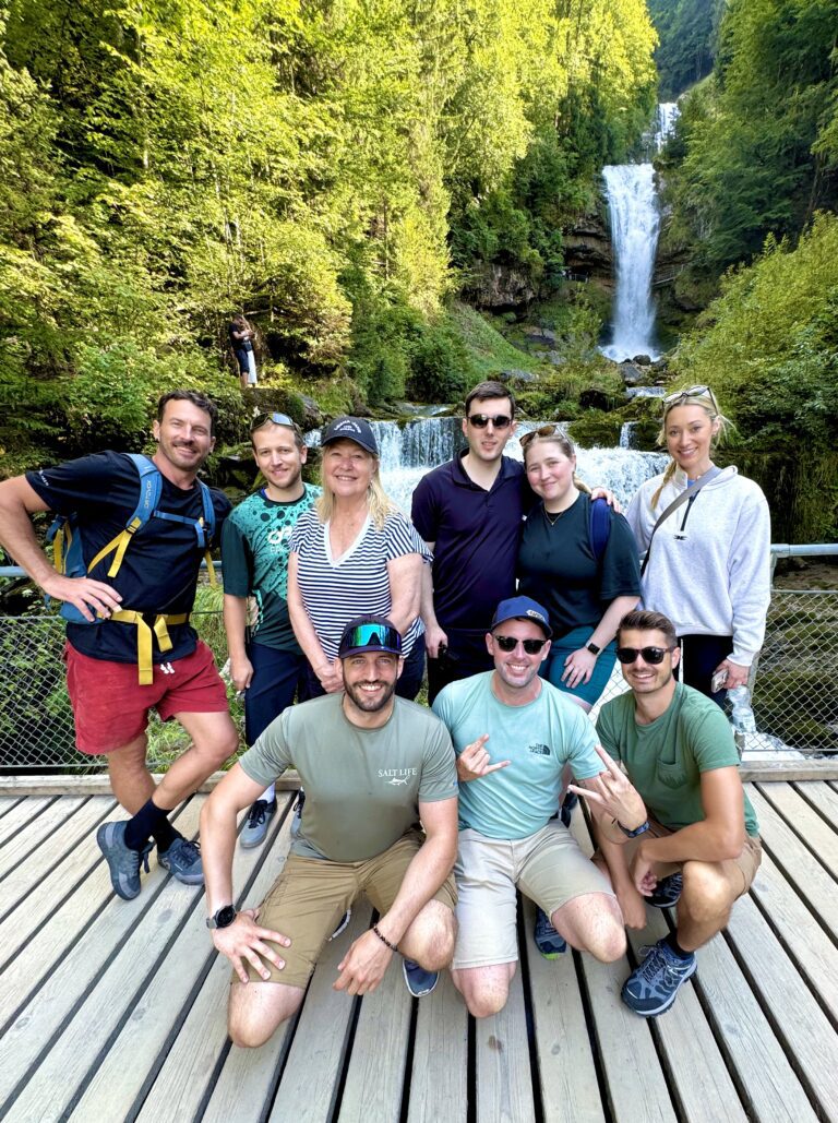 Group photo in front of the Giessbach Waterfalls near Lake Brienz during an e-bike tour from Interlaken