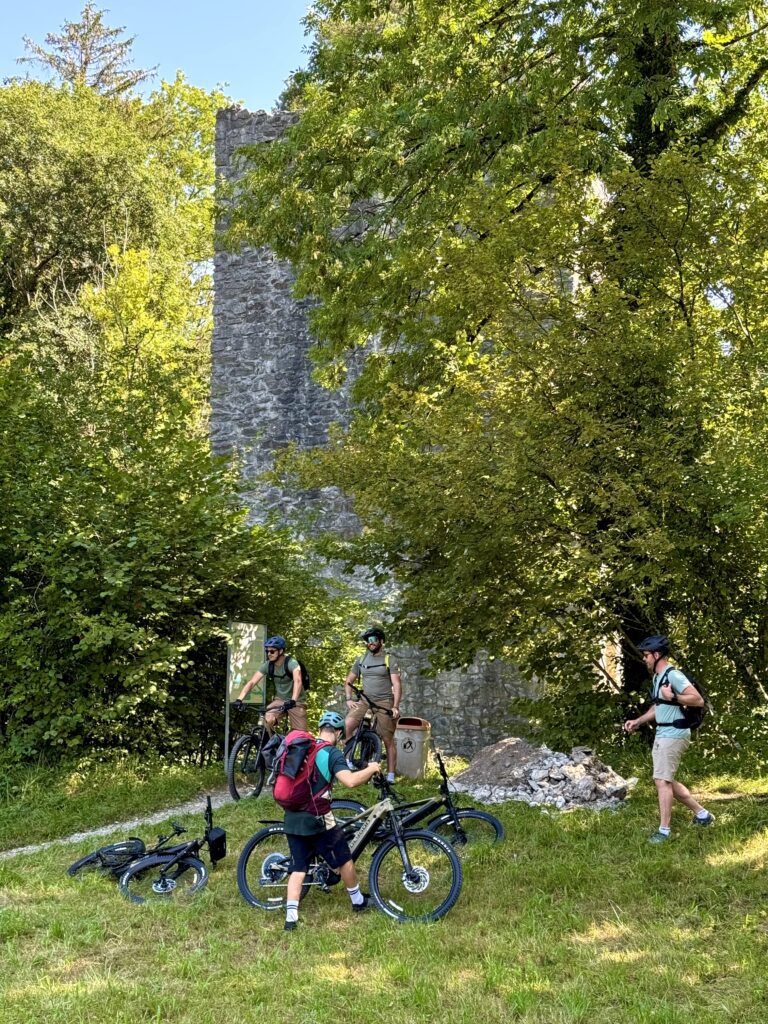 Cyclists stopping at Unspunnen Castle ruins during Interlaken E-bike Tour