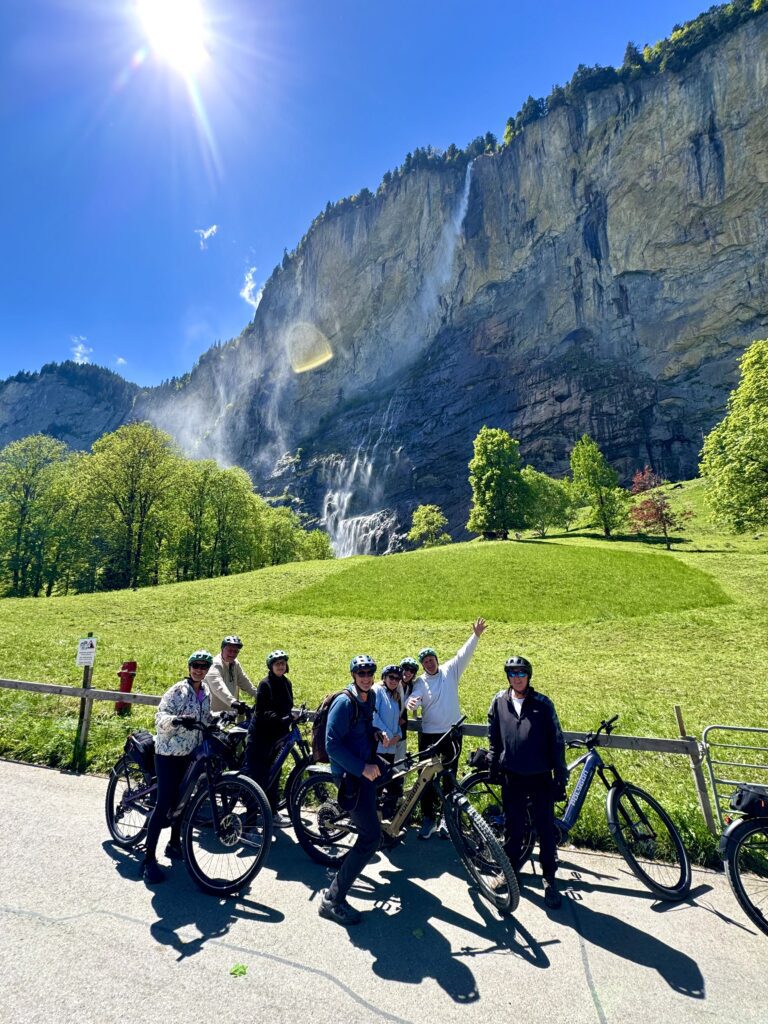 Guests on an e-bike tour beneath Staubbach Falls in Lauterbrunnen.