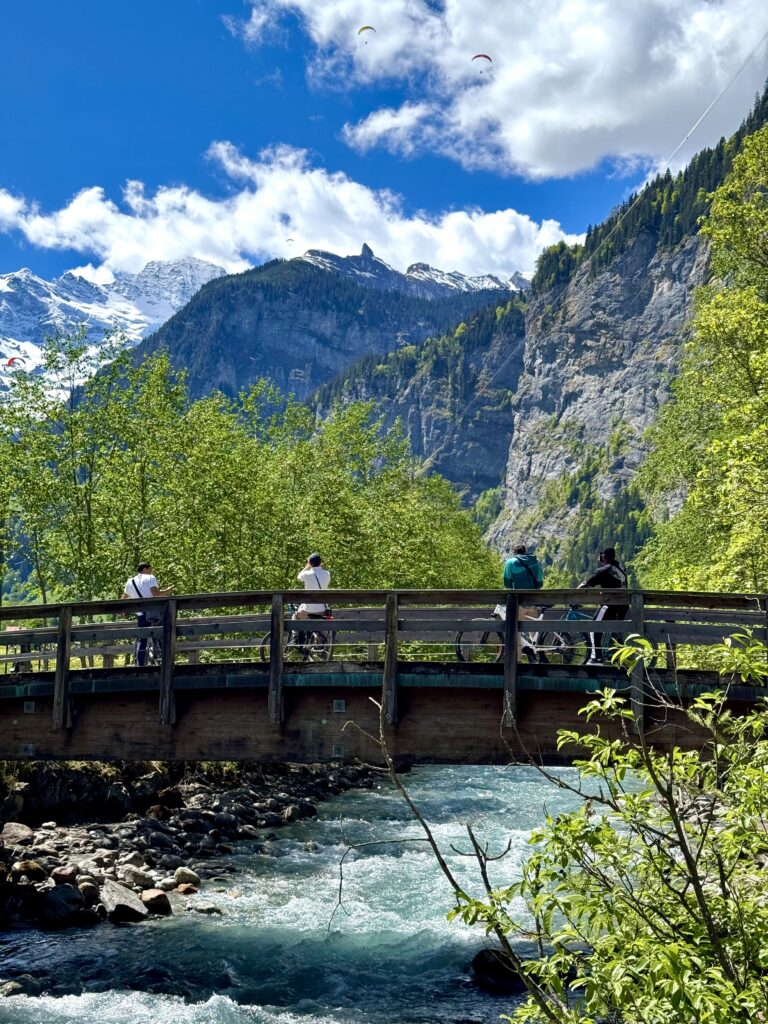 Cyclists crossing a bridge in Stechelberg during the Lauterbrunnen E-bike Tour.